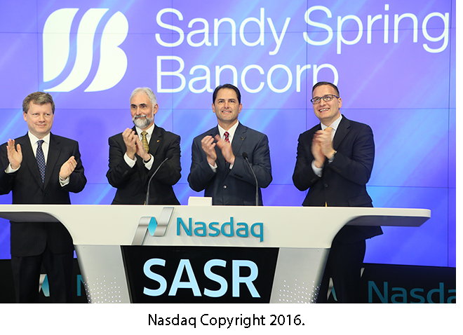 Sandy Spring Bancorp logo with Nasdaq people and Phil Mantua and Dan Schrider from Sandy Spring Bank.