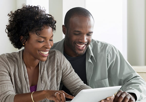 Couple smiling and lookin at their Sandy Spring Bank CDs on a laptop.