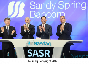 Sandy Spring Bancorp logo with Nasdaq people and Phil Mantua and Dan Schrider from Sandy Spring Bank.