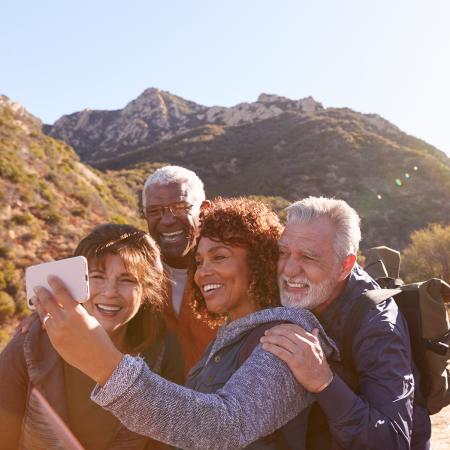 Two couples in the mountains taking a selfie.  Sandy Spring Bank Senior Interest Banking.