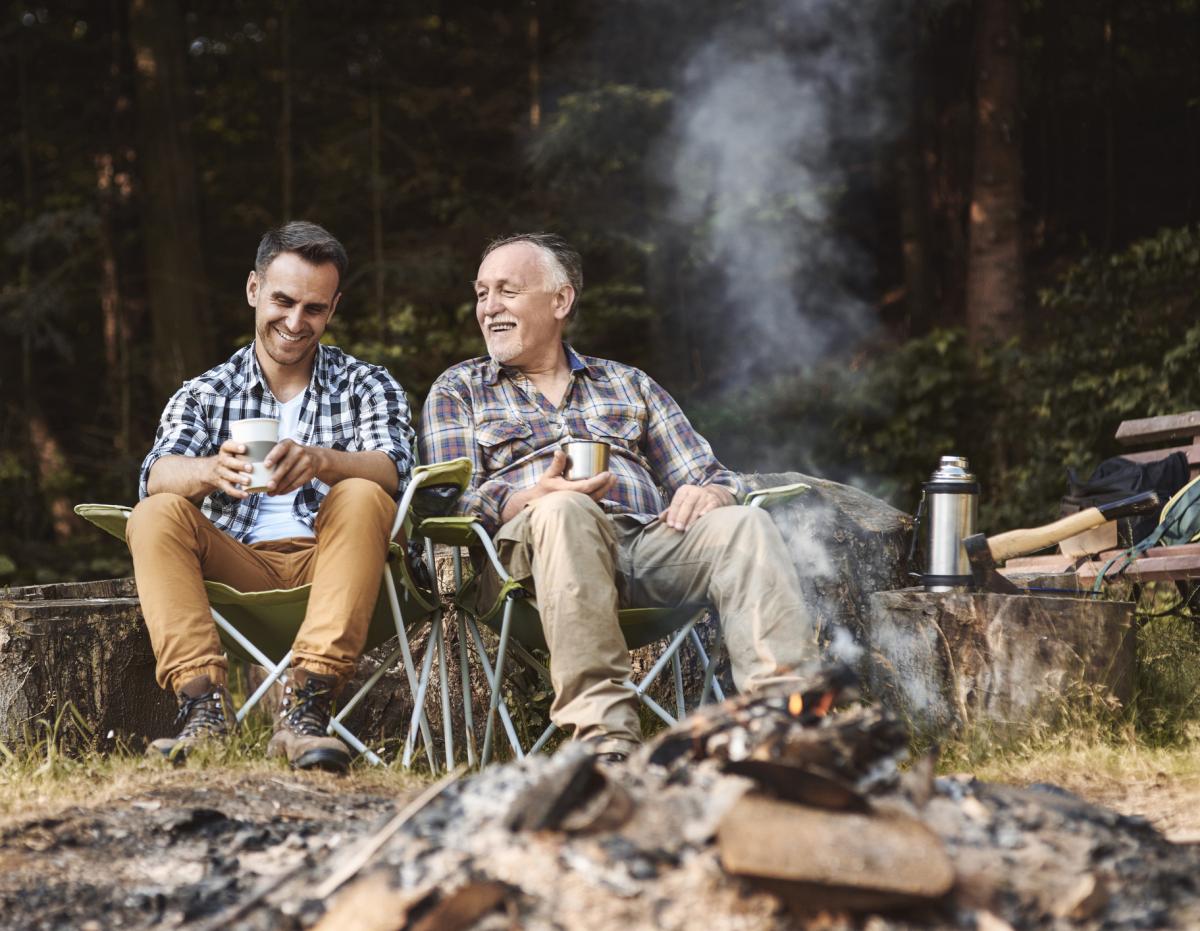 Men relaxing around a camp fire. Sandy Spring Bank